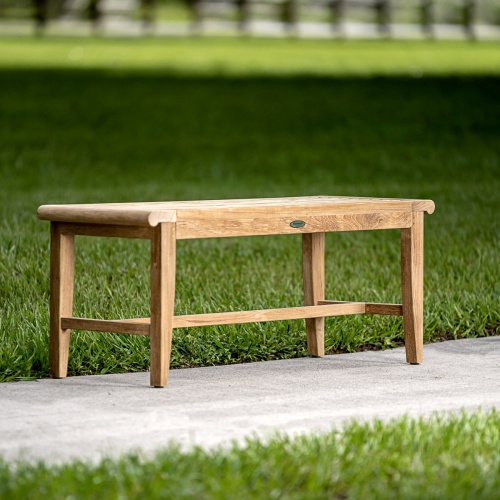 13916 Laguna teak backless garden bench on concrete walkway with grass in background