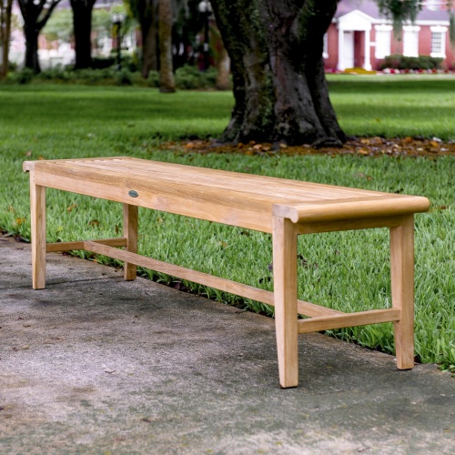 13917 Laguna 6 foot teak Backless Bench on concrete walkway with trees and grass in background 