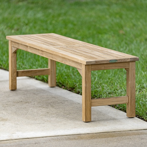 13929 Veranda teak 5 foot long Backless Bench angled end view on concrete walkway with grass in background