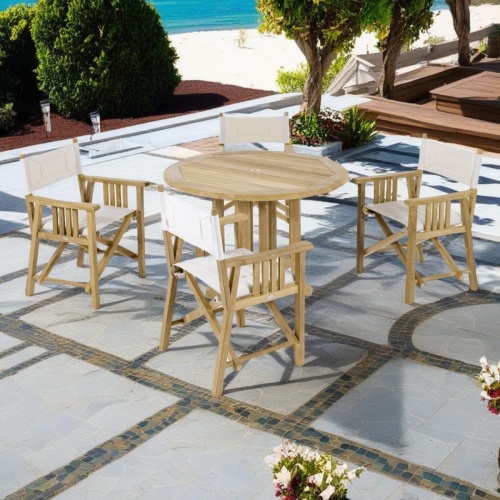 70001 Barbuda 5 piece teak Director Chair Set of Barbuda teak folding table and 4 Director Chairs on terrace with wood bench seating area trees and white beach and ocean in background