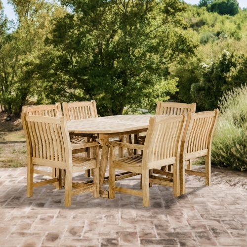70002 Montserrat 7 piece teak oval Dining Set angled on brick paver patio with trees and natural vegetation in background