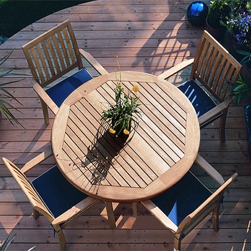 70033 Sussex Barbuda 5 piece Dining Set with optional seat cushions overhead view with potted flowering plant on center of table top on curved wooden deck with plants in background