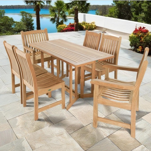 70165 Nevis Veranda 7 pc Teak Dining Set of a Nevis teak rectangular dining table and 2 Veranda dining armchairs and 4 dining side chair on patio terrace surrounded by plants with ocean and blue sky background 