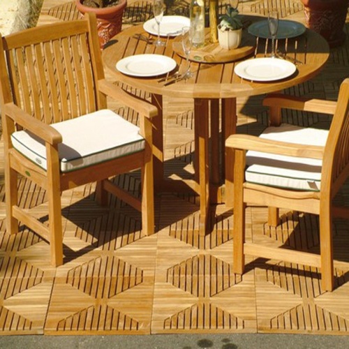 70179  Veranda Barbuda 5 piece dining set of Barbuda teak folding 48 inch round dining table with 4 place settings and 2 Veranda teak armchairs with optional seat cushions on teak tiles in background
