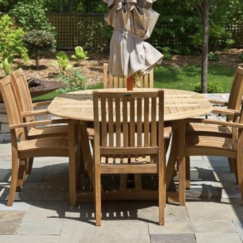 70214 Martinique Teak 7 piece Dining Set on tiled patio showing optional closed umbrella in center of table end view with grass and trees in background