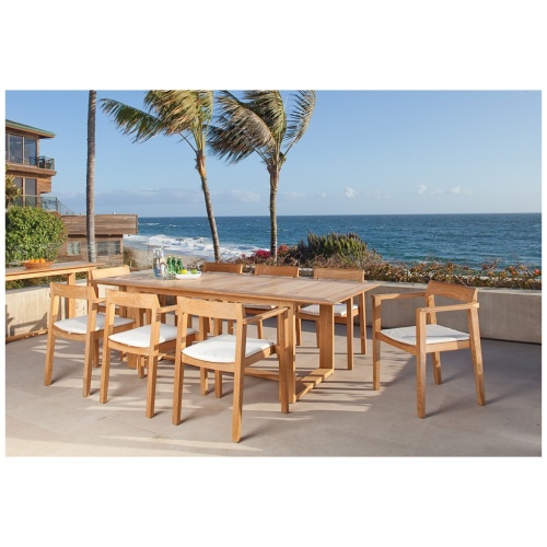 70220 Horizon teak Dining Set cushioned water pitcher three sparkling water bottles plate of limes on outdoor balcony with vegetation three palm trees beach house and ocean background 