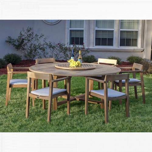70238 Buckingham Horizon teak dining set with 2 wine bottles and yellow flowers on lazy susan in center of table and optional seat cushions on grass landscape plants and house in back