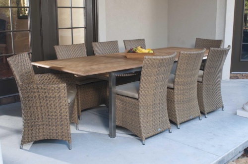 70247 Vogue Valencia Summer Grass 9 piece Dining Set on paver outdoor patio with a square teak tray of fresh fruit on table and patio doors in background