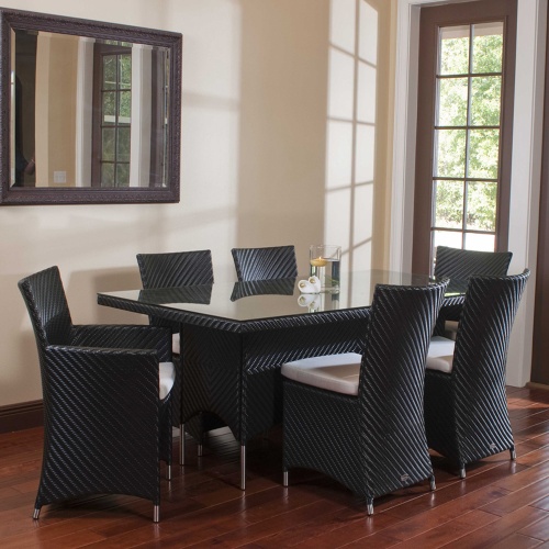 70260 Valencia wicker 7 piece dining set of 2 black armchairs 4 black side chairs and black rectangular dining table with floating candle on table indoors on wood floor with wall mirror 
