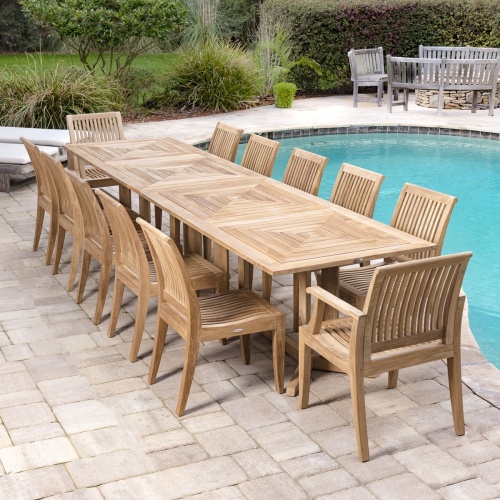 70290 pyramid teak dining set for twelve angled on paver patio with pool on side and landscaped background