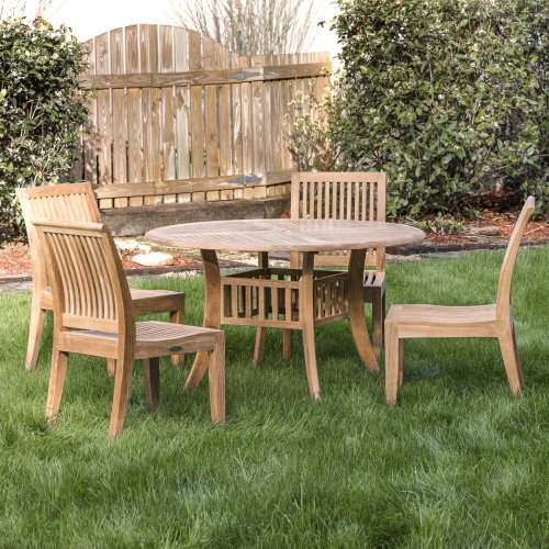 70291 Hyatt Laguna 5 piece Dining Set on grass lawn with landscaped area with shrubs and wooden fence in background