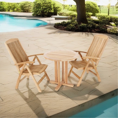 70297 Reclining 3 piece teak 30 inch round Bistro Set of 2 teak Barbuda Reclining Chairs and 30 inch round Bistro Table angled aerial view on stone pool deck with background partial view of pool with trees