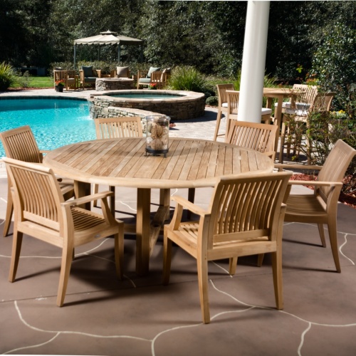 70418 Buckingham Laguna 7 piece round Dining Set with glass jar on table on stone patio with pool and hot tub and landscape plants in background