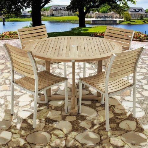 70490 Vogue teak and stainless steel dining Set of Vogue 4 ft round dining table and 4 Vogue side chairs side view on patio with lake and trees in background 