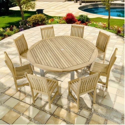 70492 Vogue Veranda 9 piece Dining Set of 8 teak side chairs and 72 inch round dining table angled view on patio surrounded by plants and trees overlooking a pool and stone deck in background 
