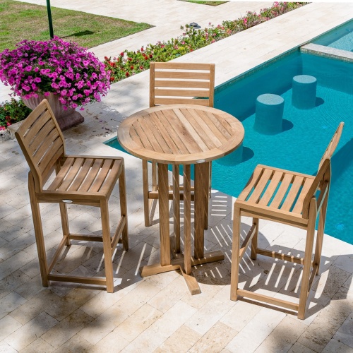 70502 Somerset 4 piece teak Bistro Bar Set of 3 barstools and Bar Table aerial view on patio next to pool surrounded by flowering plants with walkway and grass in background
