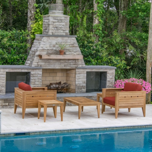 70507 Craftsman 5 piece teak Dining Set of 2 lounge chairs with cushions and 2 teak side tables and a teak coffee table on pool patio with pool in front and fireplace and shrubs in back