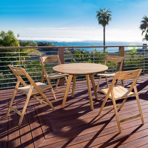 70519 Surf 5 piece teak round Dining Set of 4 folding side chairs and 42 inch round table on wooden deck overlooking pine trees with blue sky ocean view