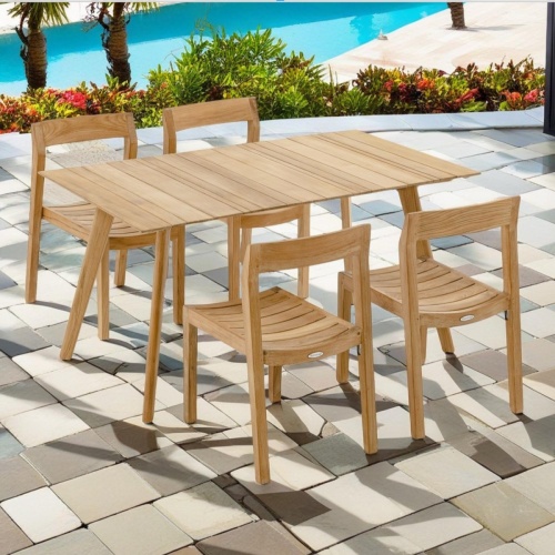 70526 Surf Horizon 5 piece Teak Rectangular Dining Set of Surf Rectangular Dining Table and 4 Horizon Side Chairs angled on stone patio surrounded by plants overlooking the pool