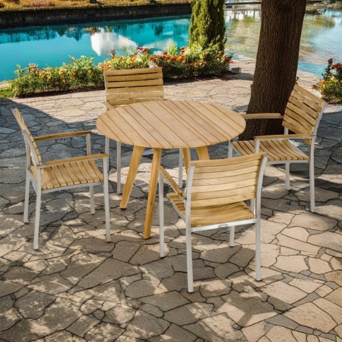 70548 Vogue and Surf Dining Set of Surf teak 42 round dining table and 4 Vogue angled view on paver patio with canal in background 