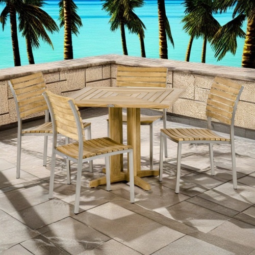 70574 Vogue Pyramid Dining Set of Pyramid Square 36 inch dining table and 4 Vogue Teak and Stainless Steel Chairs angled view on terrace with palm trees and ocean background 