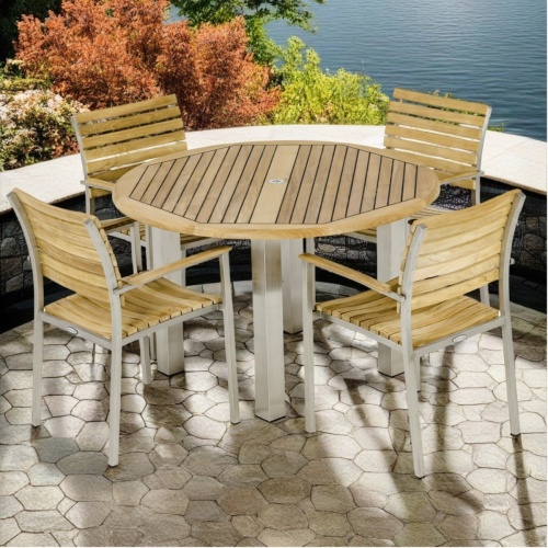 70625 Vogue teak and stainless steel Round 48 inch diameter Dining Set angled side view on outdoor stone terrace overlooking a lake with trees in background 