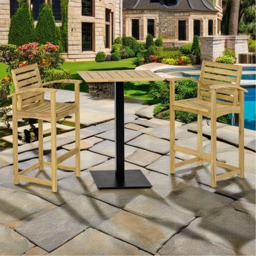 70641 Somerset Vogue barstool Bar Set showing2 teak barstools with armrests and a teak and stainless steel rectangular bar table on paver patio next to a pool with house in background 