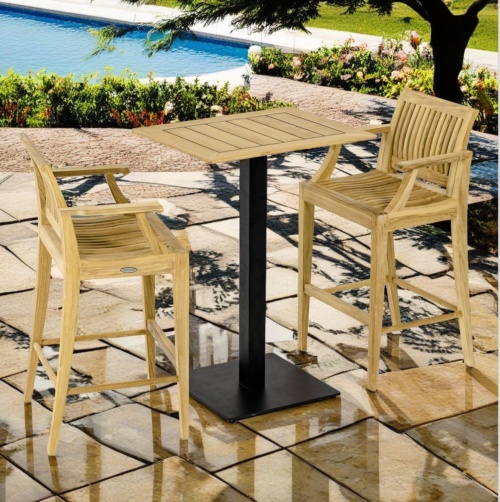 70642 Rectangular Vogue Bar Set with 4 Laguna teak bar stools angled view on paver pool deck surrounded by landscape plants and pool in background