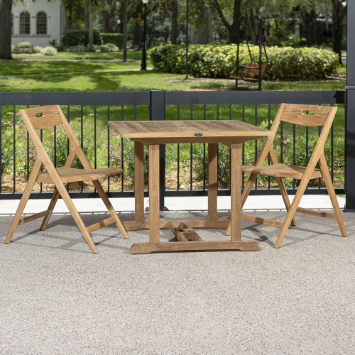 70652 Surf Square Teak 3 piece Dinette Set of 2 Surf folding chairs and teak 36 inch square table on patio with grass area and swing and house in background