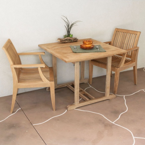 70654 Laguna Square 3 piece teak Dinette Set showing plant and 2 plates and 2 bowls a fork and spoon set on stone patio against a wall 