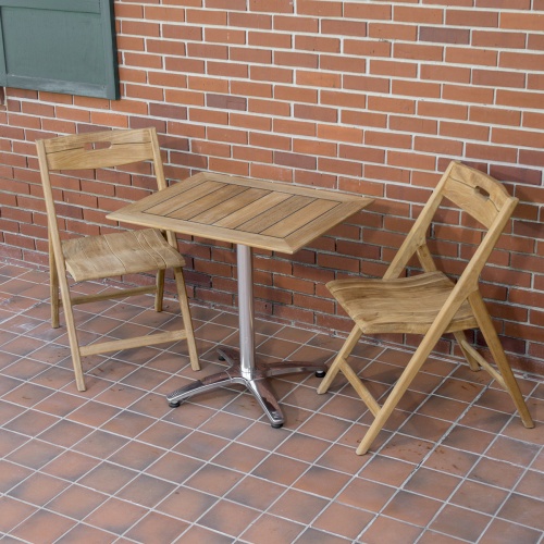 70672 Surf 3 piece teak folding Dining Set of 2 folding teak side chairs and rectangular teak and stainless steel bistro table on patio with brick wall and window shutter in background