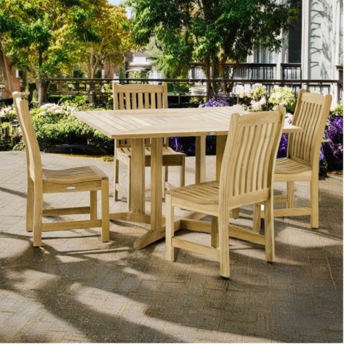 70709 Veranda Pyramid 5 piece Bistro Dining Set of 4 Veranda teak side chairs and Pyramid teak 48 inch square dining table angled on outdoor terrace and plants and railing in the background 