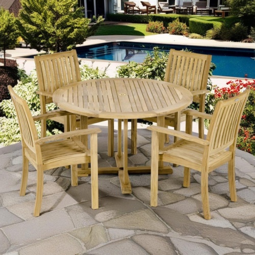 70737 Sussex teak Round Dining Set angled top view with 4 armchairs and round 48 inch round dining table on paver pool deck with pool and plants and trees in background 