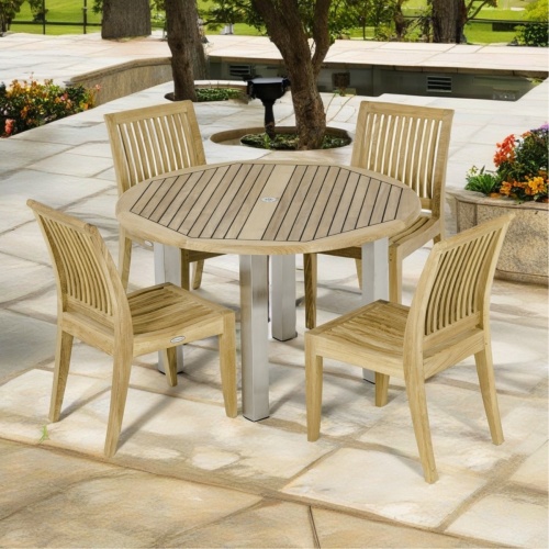 70739 Vogue Laguna round Dining Set of a teak and stainless steel 48 inch round dining table and 4 teak side chairs on patio with trees and grass in background