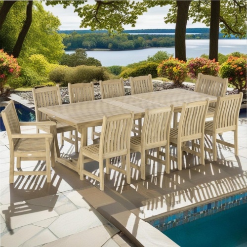70791 Veranda 11 pc teak Dining  Set of  Grand Veranda Rectangular Dining Table and 8 Veranda Side Chairs and 2 Armchairs on pool deck surrounded by plants and trees  with water inlet in background