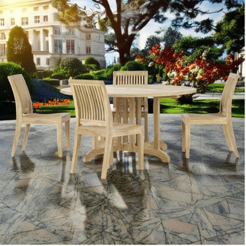 70851 Barbuda Laguna 7 piece Dining Set of Barbuda 60 Inch round table and 4 Laguna side chairs side view on pavers with mansion in background
