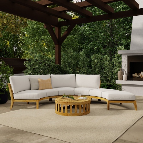 70934 Kafelonia 4 piece Curved Sofa Sectional Set front view sitting on rug on outdoor patio with a pergola and fireplace and shrubs in background