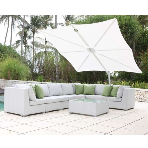 sp2590set spectra solo umbrella and paver base with sectional set on concrete patio with pool on one side trees and shrubs in background