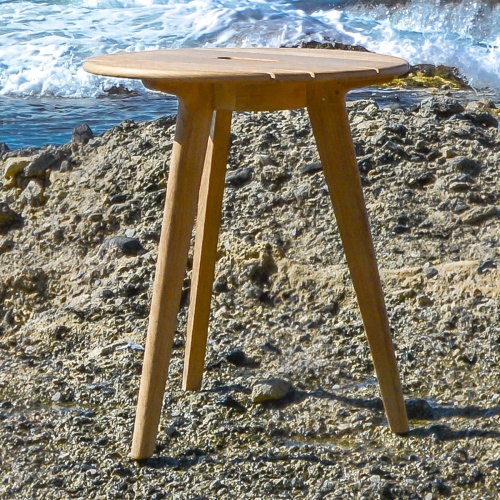 14916 surf teak side table on gravel beach with ocean waves in background