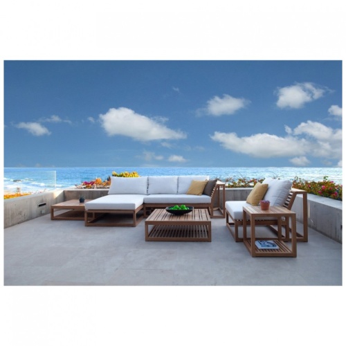 16800RFDP teak Maya Chaise Daybed shown with maya left side sofa and maya slipper chair on terrace with planters of landscape plants with ocean and blue sky background