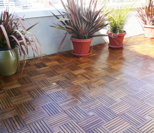 18411DM Parquet Teak Floor Tiles on floor with 3 potted plants and windows in background