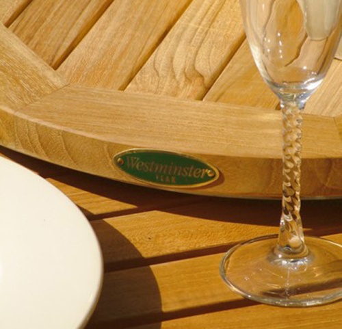 40001 Westminster Teak logo replacement plate on side of our teak lazy susan next to glass of wine and white plate