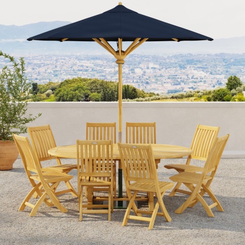 70060 Barbuda Martinique 9 pc Dining Set in side view with optional umbrella on outdoor terrace next to potted tree with hillside view with homes in background 