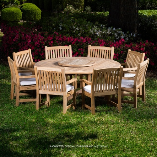 70173 Buckingham teak 9 pc Dining Set with optional seat cushions and optional lazy susan in table center on grass lawn with flowers and tree in background