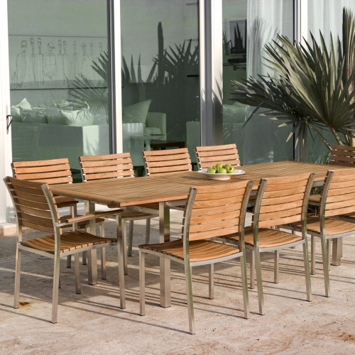 70176 Vogue stainless steel and teak rectangular dining set for ten with white plate of green apples on concrete patio palmetto palm and glass door in background