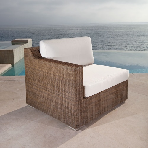  70241 malaga woven wicker right side sectional canvas cushions on outdoor patio angle view with infinity pool and ocean backdrop