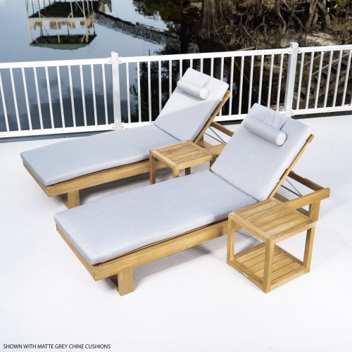 70309 Horizon teak double chaise set with cushions left side angled aerial view on concrete deck with metal railing trees boathouse and dock in background