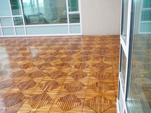 70410 diamond teak floor tiles assembled together on condo deck with windows in background
