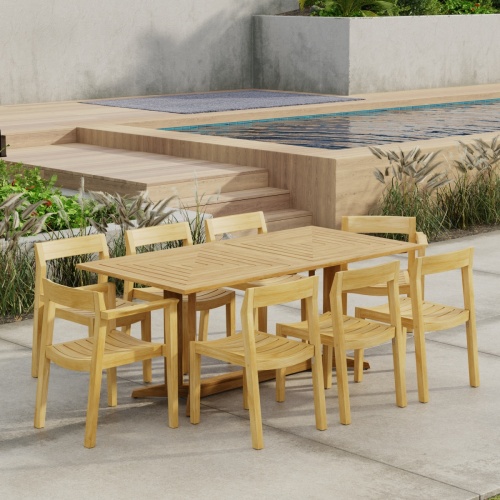 70462 Pyramid Horizon 9 pc Teak Dining Set  in angled side view on patio next to pool with landscape plants and privacy wall in background