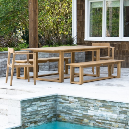  70496 Horizon five piece teak dining backless bench set angled on outdoor patio facing pool with landscape and window background